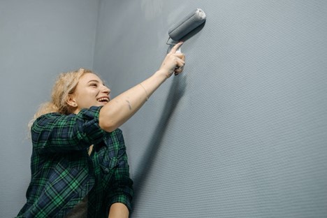 Woman painting wall with roller image